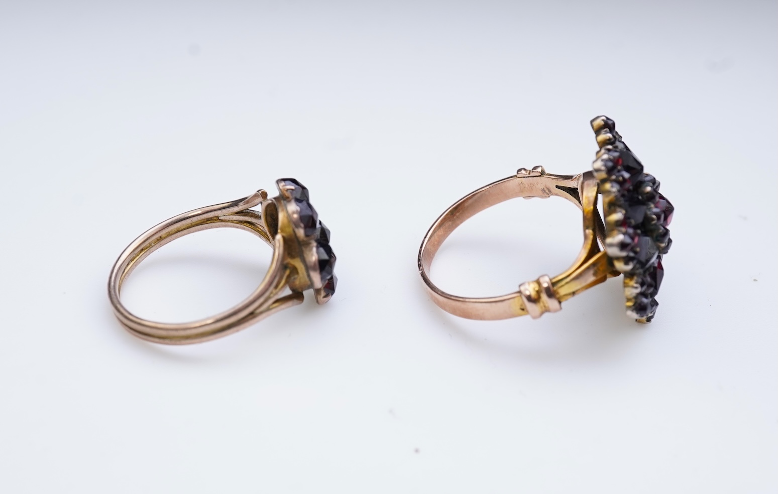 A suite of garnet and paste jewellery, comprising: a brooch, 5cm diameter; a bangle, inner circumference 16cm; two rings, sizes I and M; a pair of earrings, and a single earring, each set with rose-cut garnets; and a pai